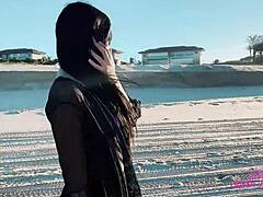 To modne kvinner borer en tenåringsjente på stranden