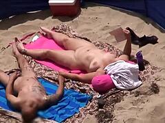 Donne mature godono del sole e l'una con l'altra in spiaggia