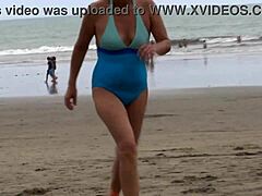 امرأة ناضجة ذات ثدي طبيعي تتعرض لنيك شديد على الشاطئ.