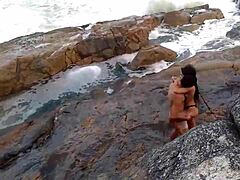 Uma mulher africana madura com seios naturais é fodida na frente da praia
