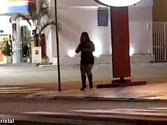 Une femme mature montre ses courbes dans une station-service après la tombée de la nuit