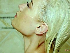 Blond skönhet visar upp sin lockande kropp i en duschscen