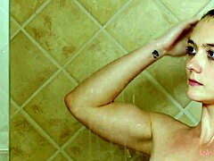 Aantrekkelijke brunette model baadt in een hete douche