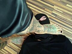 Una MILF tatuada domina a su esclava de pies en un video caliente descalzo