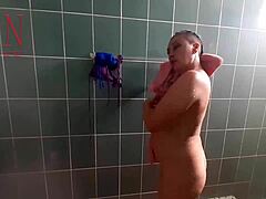 Regina Noir, nahá hospodyně, se sprchuje a holí si genitálie, zatímco ji někdo sleduje