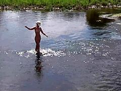 Een volwassen Russische vrouw neemt een naaktbad in de open lucht